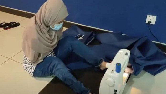 Mujer sin brazos hace cubrebocas coronavirus 696x394